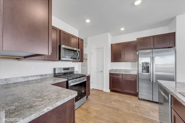 a kitchen with stainless steel appliances granite countertop a sink stove and refrigerator