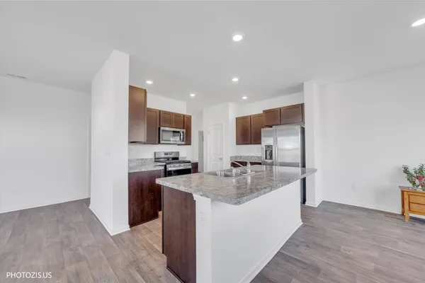 a kitchen with stainless steel appliances granite countertop a sink a stove and a refrigerator