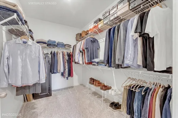 a view of walk in closet with clothes and shoes
