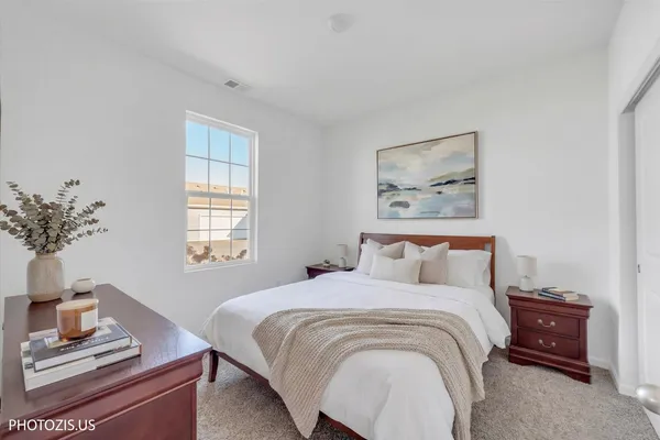 a bedroom with a bed and a potted plant