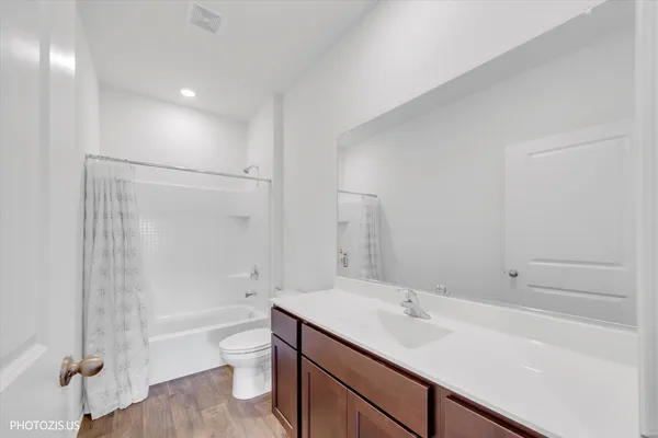 a bathroom with a granite countertop sink a toilet and shower