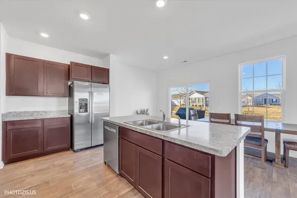 a kitchen with stainless steel appliances granite countertop a sink refrigerator and cabinets