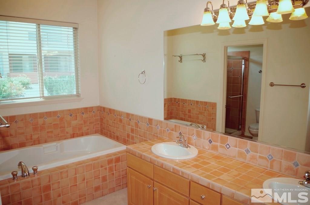3327 Skyline Boulevard Reno, NV 89509 - Photo 13 of 17 a bathroom with a granite countertop sink and a mirror