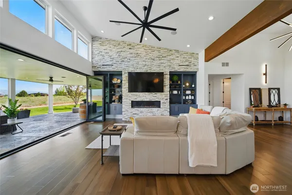 a living room with fireplace furniture and a large window