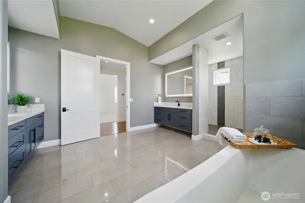 a bathroom with a tub sink and mirror