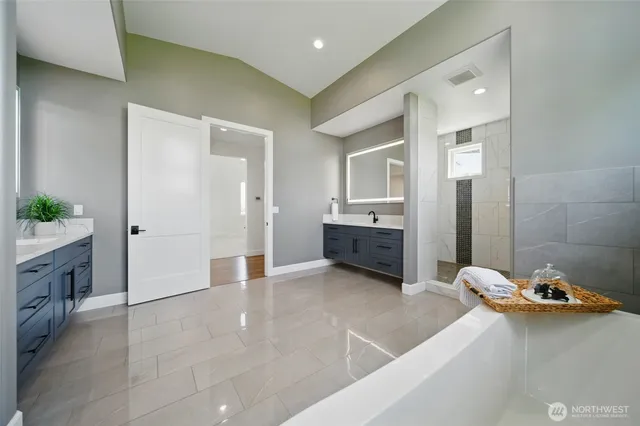 a bathroom with a tub sink and mirror