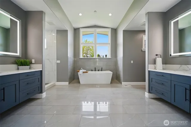 a spacious bathroom with a tub sink and mirror