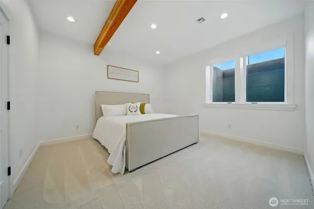 a white bed sitting in a room next to a window