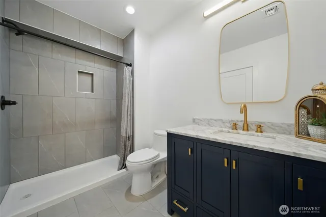 a bathroom with a granite countertop sink toilet and shower