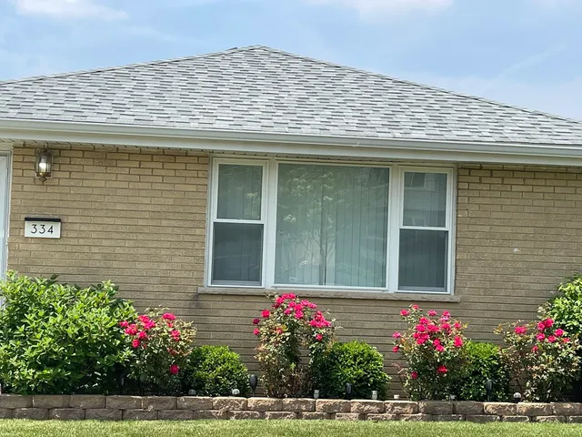 a front view of house with flowers
