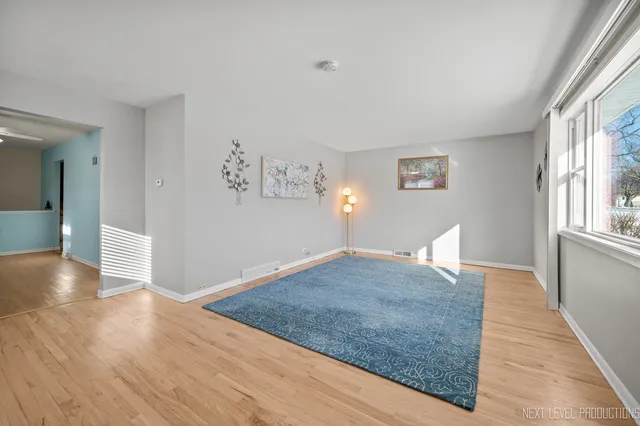 a view of a livingroom with wooden floor and a large window