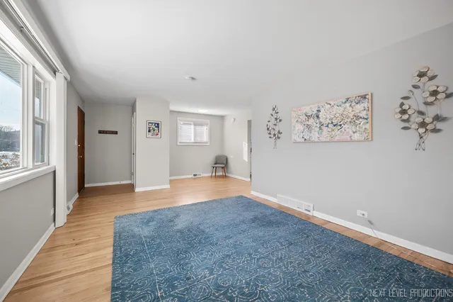 a view of a big room with wooden floor and windows