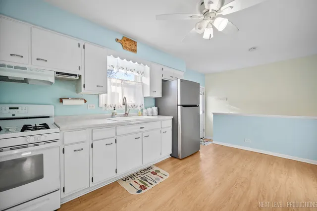 a kitchen with granite countertop white cabinets and white appliances