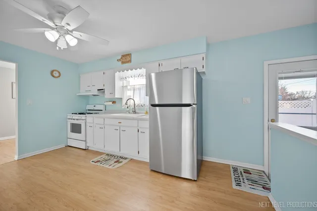 a kitchen with white cabinets and white appliances