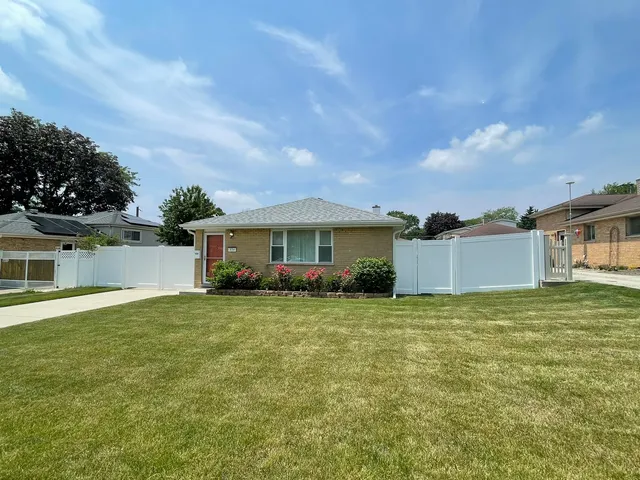 a front view of a house with a garden and yard