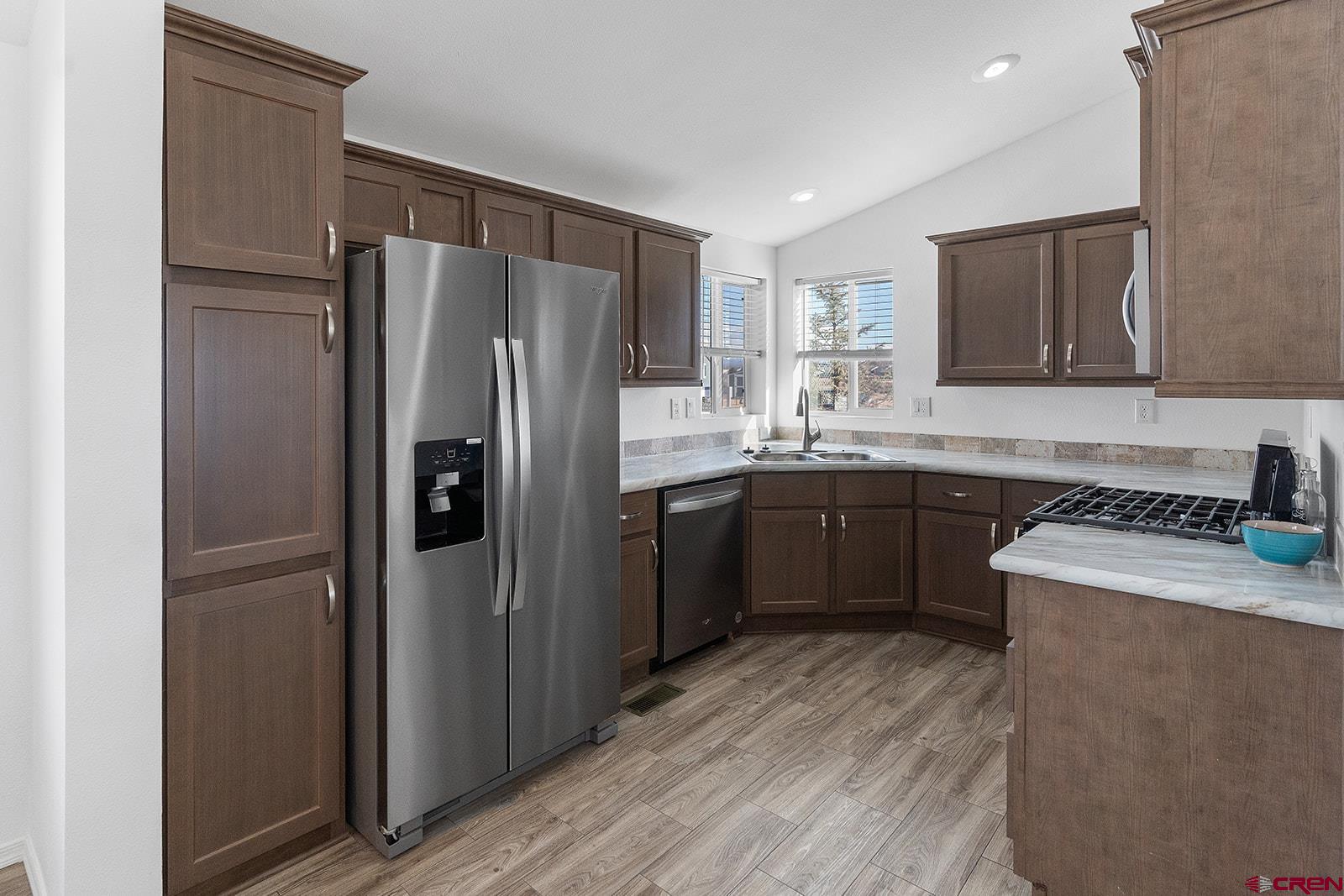 901 6530 Road, Unit 2836 Montrose, CO 81401 - Photo 6 of 21 a kitchen with a sink a refrigerator and a stove top oven