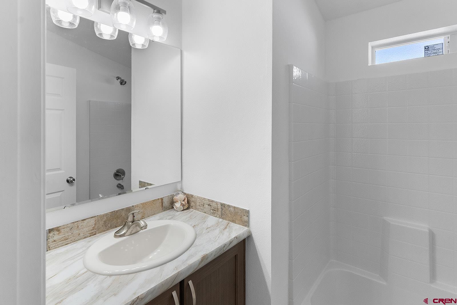 901 6530 Road, Unit 2836 Montrose, CO 81401 - Photo 9 of 21 a bathroom with a sink a light fixture and a mirror