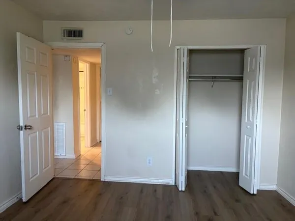 an empty room with wooden floor and closet