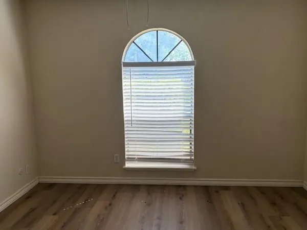 an empty room with wooden floor and a window