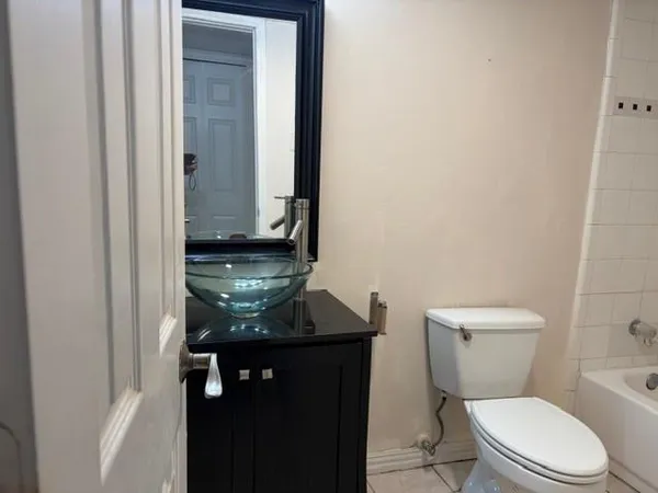a bathroom with a granite countertop toilet and a sink