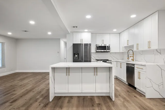 a kitchen with a sink stainless steel appliances and cabinets