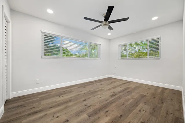 a view of a big room with wooden floor and windows