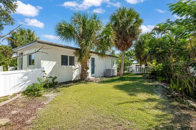 a view of a house with a yard and large tree