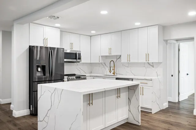 a kitchen with stainless steel appliances a refrigerator sink and microwave