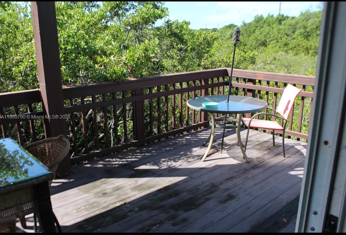 202 West Canal Drive Key Largo, FL 33037 - Photo 24 of 29 a view of a chairs and table on the wooden deck
