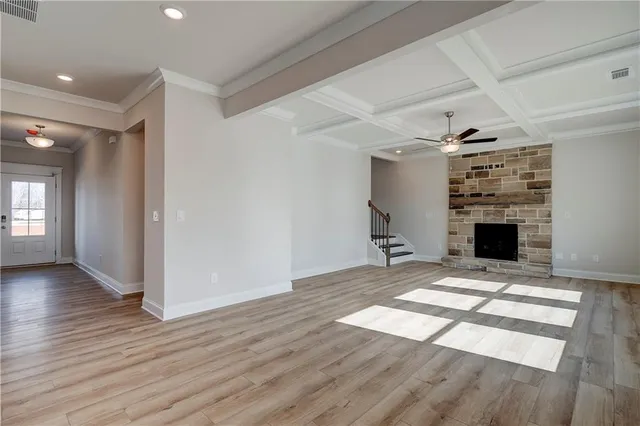 a view of empty room with wooden floor and fireplace