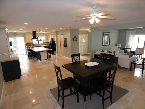 a view of a dining room and livingroom with furniture a rug a rug and a chandelier