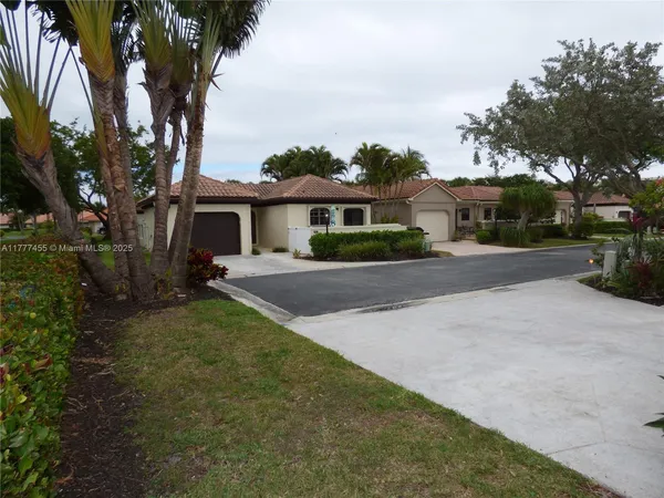 a front view of a house with a yard and trees