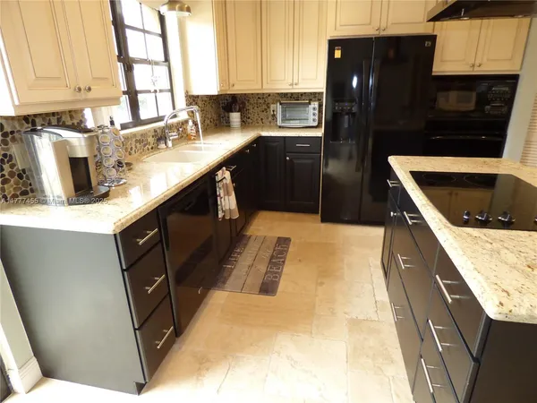 a kitchen with a sink a stove and cabinets