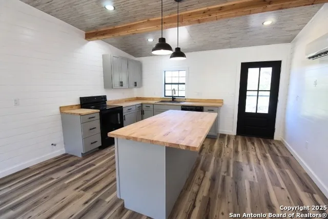 a kitchen with a stove and wooden floor