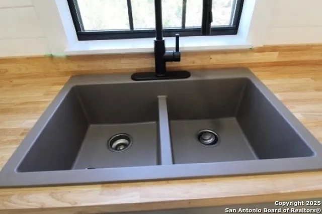 a view of a room with wooden floor chandelier and windows