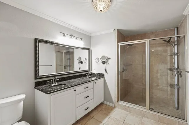 a bathroom with a granite countertop sink and a toilet