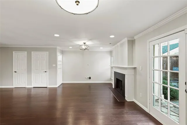 an empty room with wooden floor and fireplace