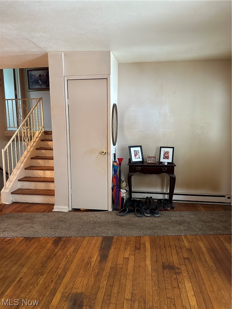 49890 Middle Ridge Road Amherst, OH 44001 - Photo 12 of 26 Foyer entrance featuring dark hardwood / wood-style flooring, a baseboard radiator, and a textured ceiling