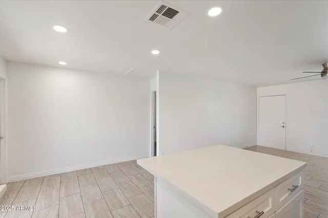 an empty room with a window and a fan