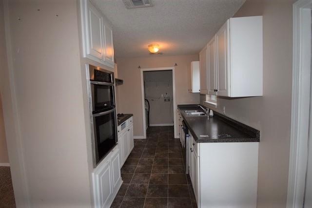 1508 McCauley Road Baker, FL 32531 - Photo 5 of 12 a kitchen with granite countertop a refrigerator a stove and a sink