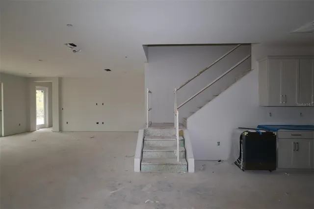 a view of an empty room with stairs and ventilation