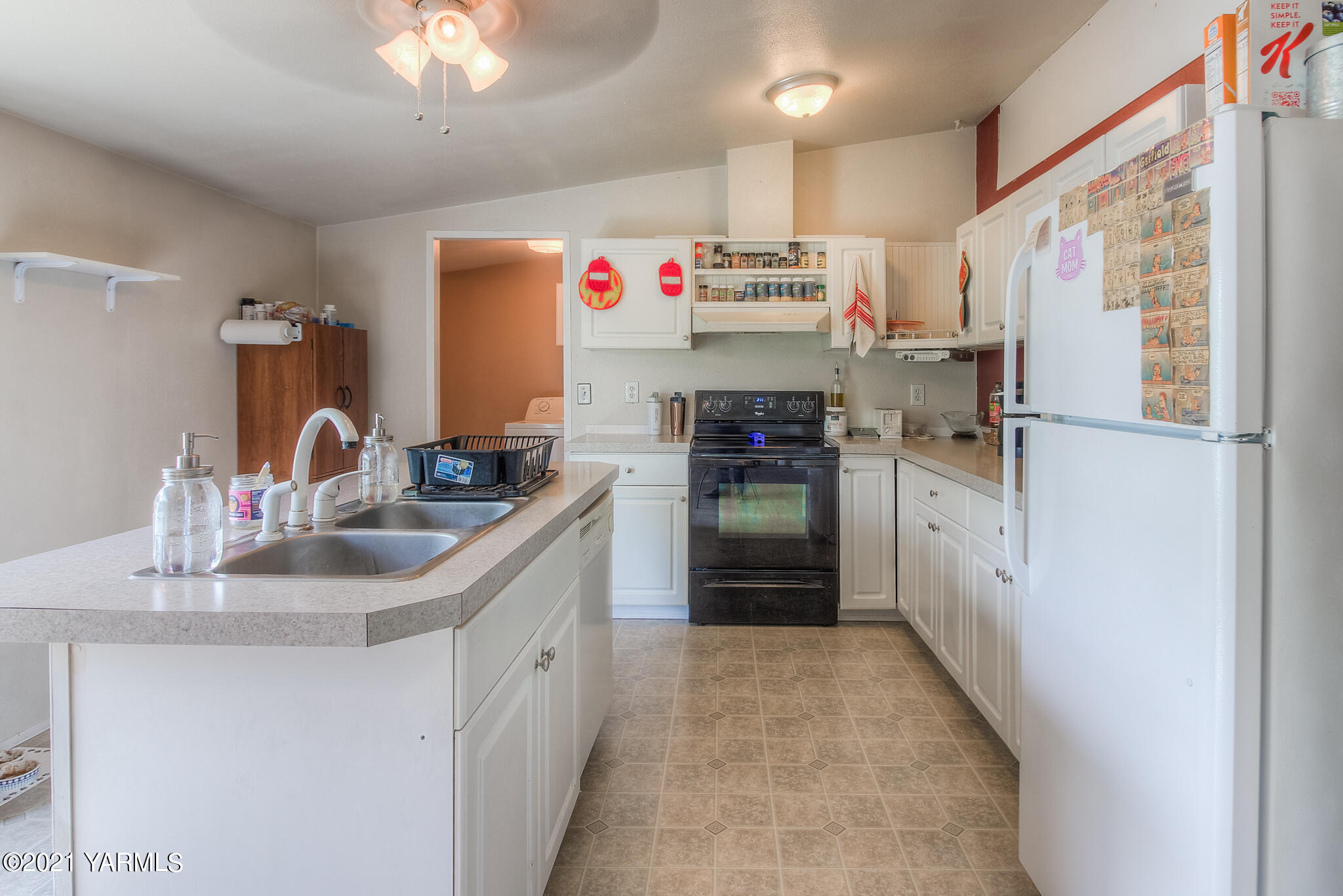 10204 Meadowbrook Road Yakima, WA 98903 - Photo 8 of 29 a kitchen with refrigerator a sink and cabinets