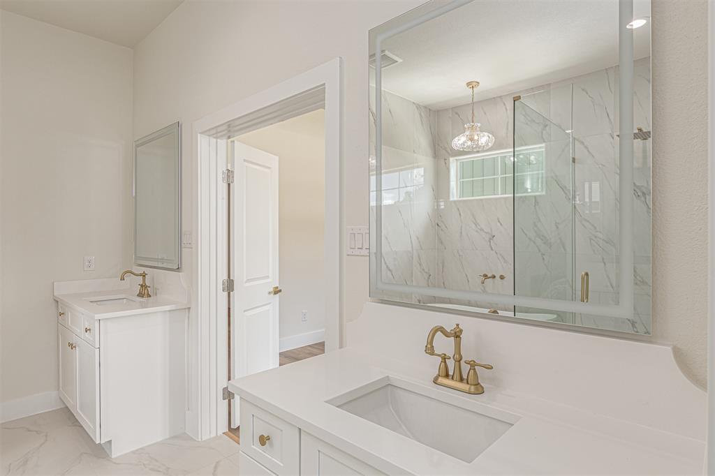 360 Dalton Road Canton, TX 75103 - Photo 18 of 33 Dual vanity featuring white cabinetry, quartz countertops, and brass-finish fixtures