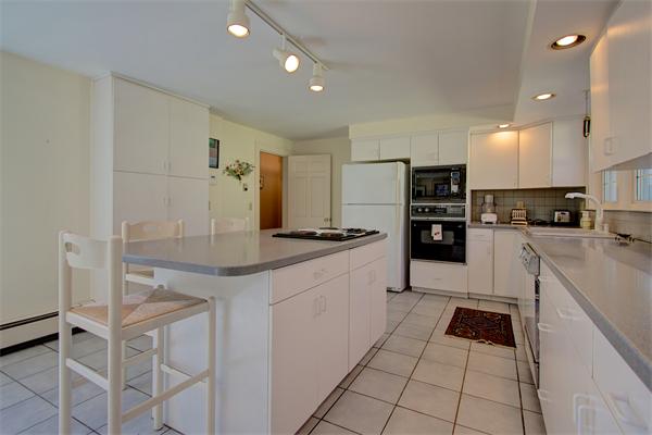 110 Belknap Road Framingham, MA 01701 - Photo 14 of 30 a kitchen with kitchen island granite countertop a stove a sink and a refrigerator
