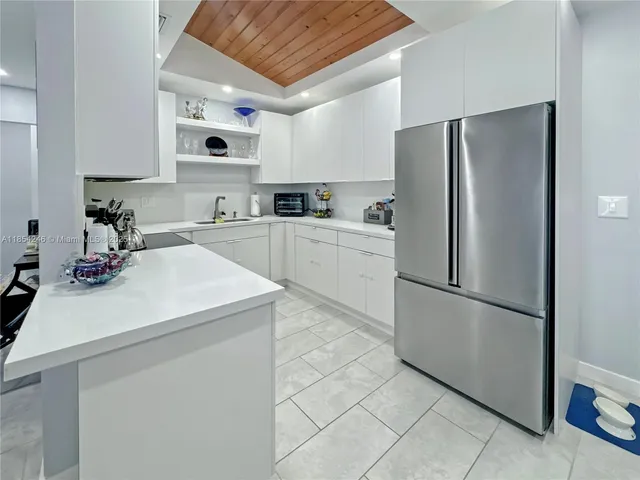 a kitchen with a refrigerator sink and white cabinets