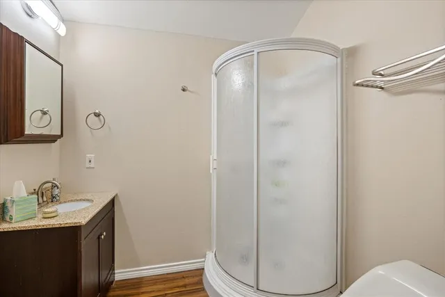 a bathroom with a granite countertop sink toilet and shower
