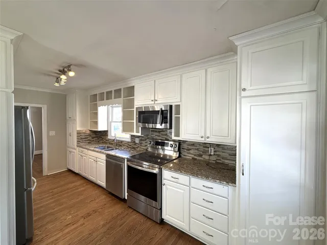 a kitchen with stainless steel appliances granite countertop a stove and a refrigerator