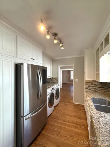 a kitchen with a refrigerator and wooden floor