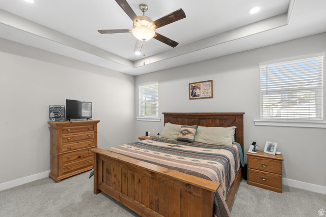 3678 Spiral Springs Road, Unit 204 Tooele, UT 84074 - Photo 27 of 59 Tray ceiling with recessed lighting, ceiling fan, two windows with blinds, and light gray wall paint