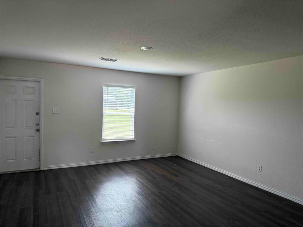 404 Munson Street Denison, TX 75021 - Photo 5 of 6 an empty room with wooden floor and windows